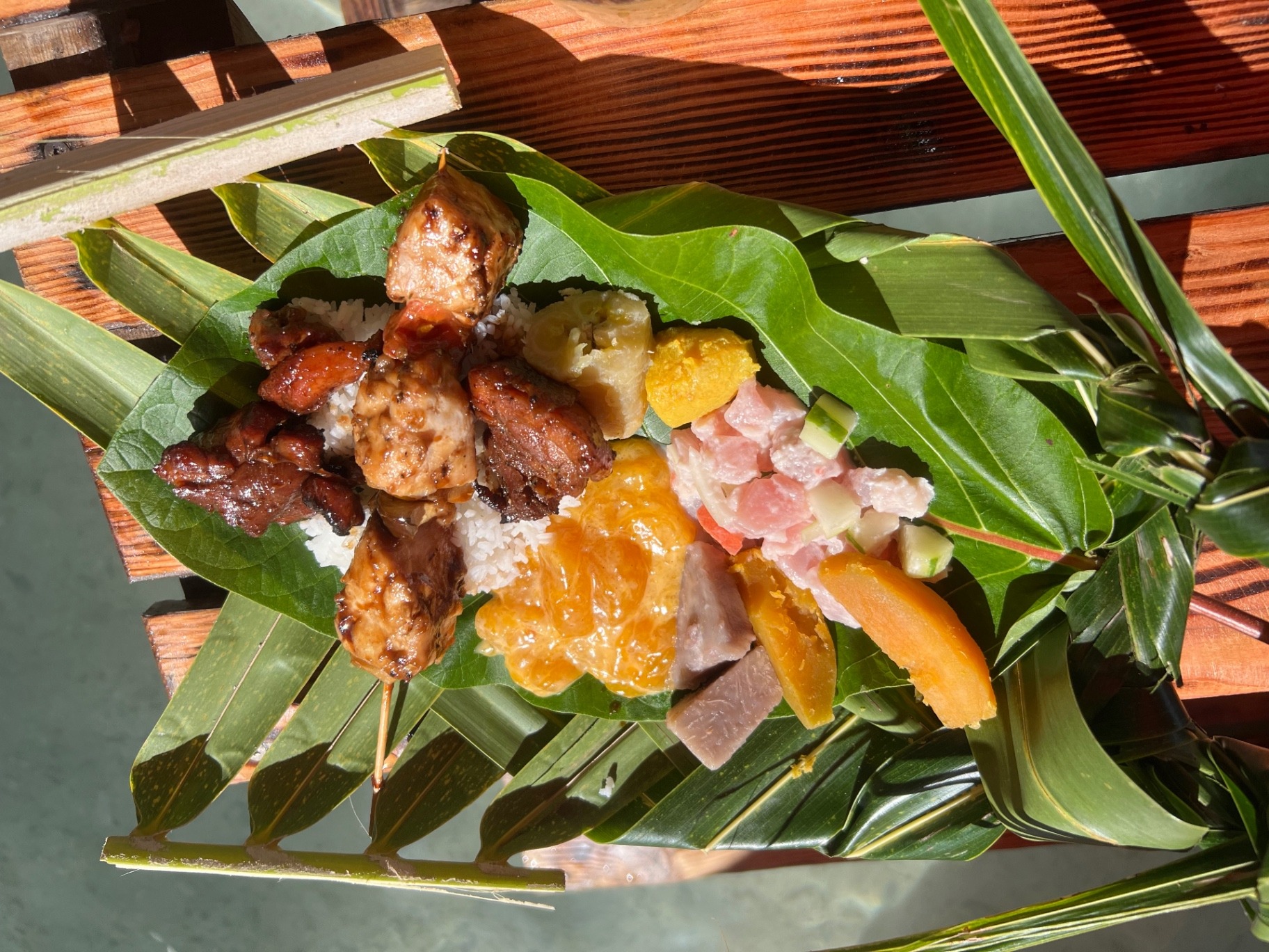 Traditional Polynesian lunch served on leaf plates at a private motu in Tahaa, French Polynesia