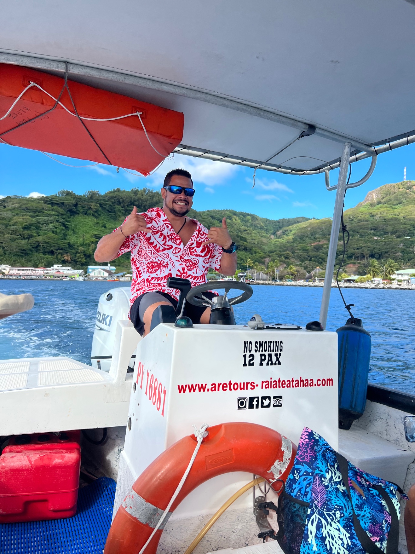 Aretours guide at the helm of the boat crossing the Tahaa lagoon, French Polynesia